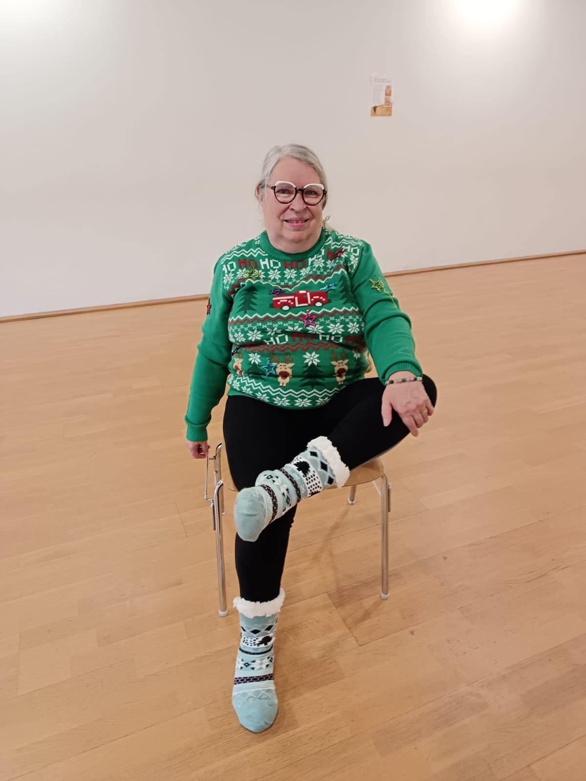 Adhérente en pull de Noël faisant un exercice d'équilibre